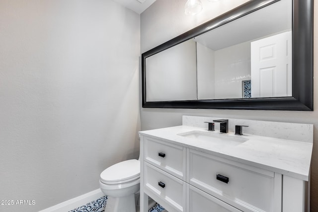 half bathroom featuring baseboards, vanity, and toilet