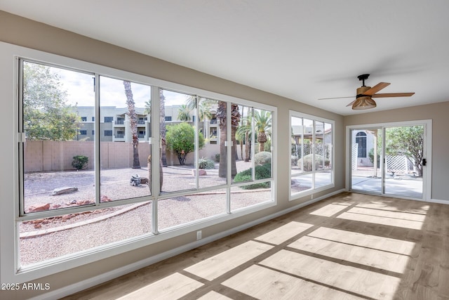 unfurnished sunroom with ceiling fan