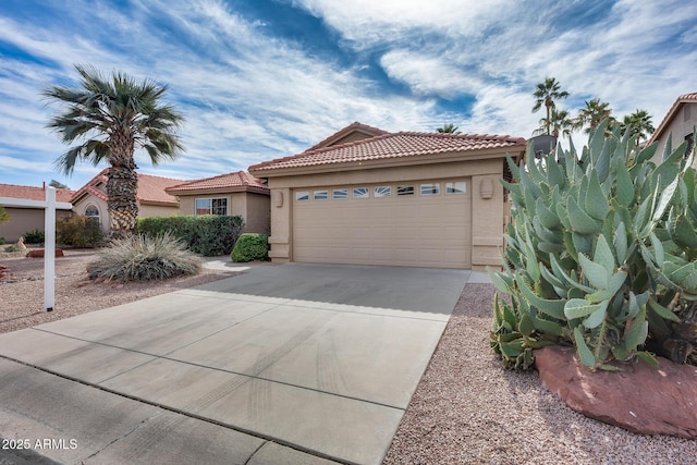 view of front of home featuring a garage, driveway, a tile roof, and stucco siding