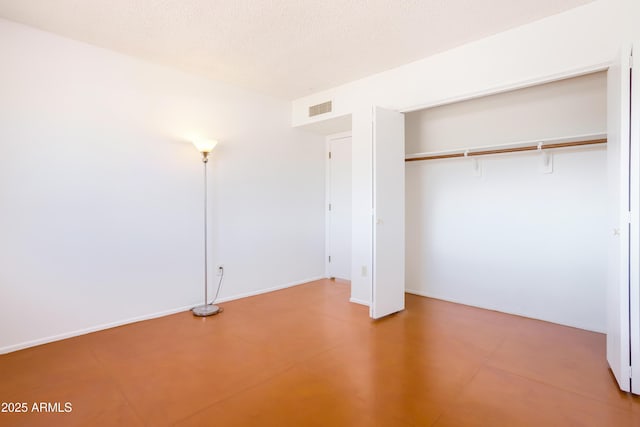 unfurnished bedroom featuring a textured ceiling, a closet, and visible vents