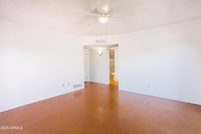 empty room featuring a ceiling fan, visible vents, and a textured ceiling