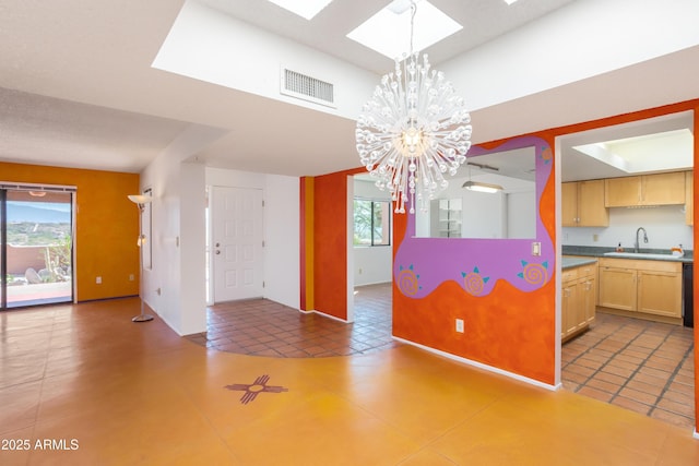 kitchen featuring visible vents, light countertops, light brown cabinets, a chandelier, and pendant lighting