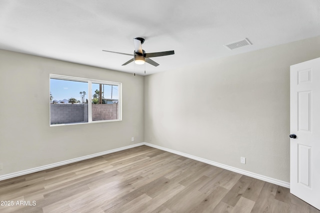 empty room featuring baseboards, visible vents, ceiling fan, and light wood finished floors