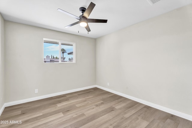 spare room featuring baseboards and light wood finished floors