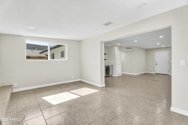 spare room featuring baseboards, visible vents, and recessed lighting