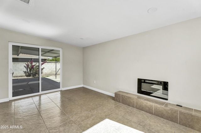 unfurnished living room with a fireplace and baseboards