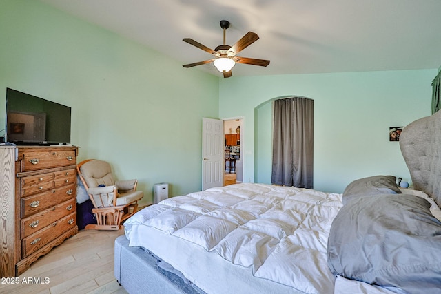 bedroom featuring lofted ceiling, ceiling fan, and light wood-style flooring