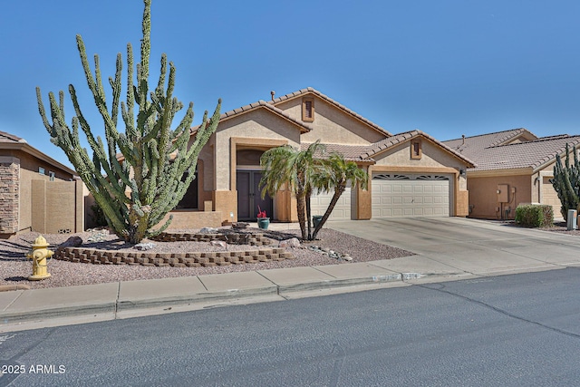 view of front of home with a garage, concrete driveway, a tile roof, and stucco siding