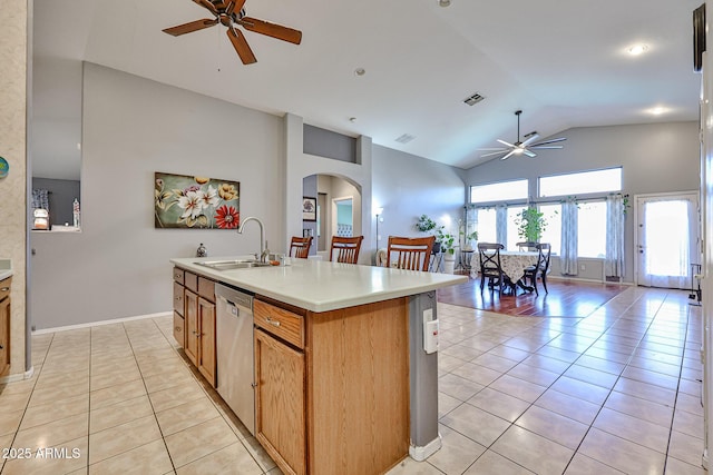 kitchen with arched walkways, light tile patterned floors, open floor plan, a sink, and dishwasher