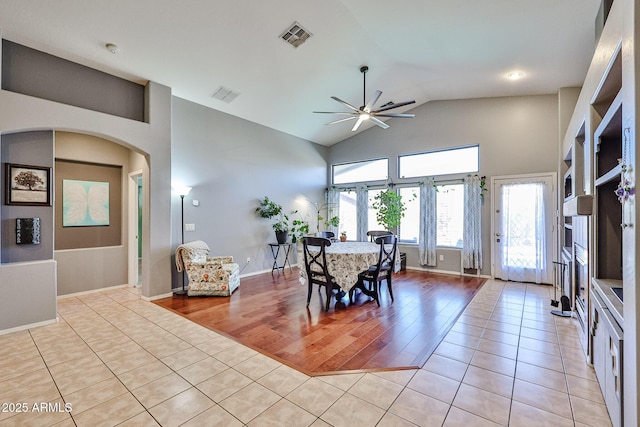 dining space with high vaulted ceiling, light wood finished floors, visible vents, and a ceiling fan