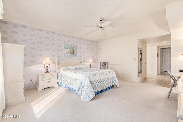 carpeted bedroom with ceiling fan and a textured ceiling