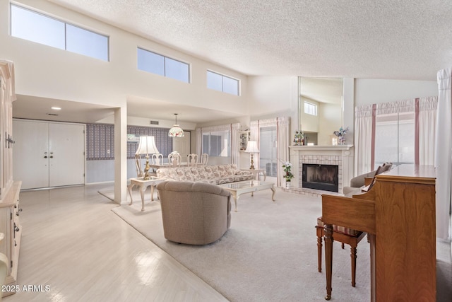 living room featuring a high ceiling, a textured ceiling, and light wood-type flooring