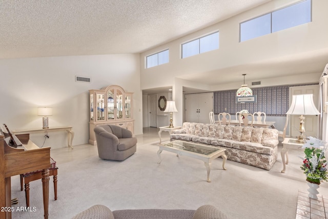 living room featuring light carpet, a towering ceiling, and a textured ceiling