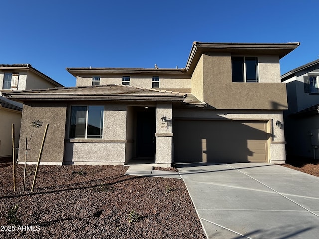 view of front of property featuring a garage, concrete driveway, and stucco siding