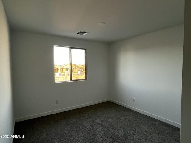 unfurnished room featuring baseboards, visible vents, and dark colored carpet