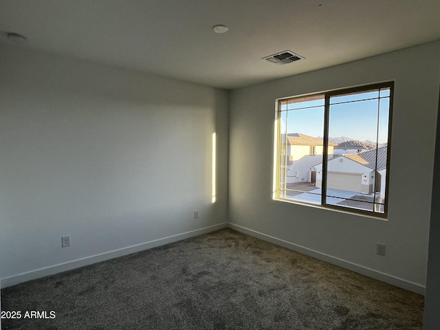 carpeted empty room with visible vents and baseboards