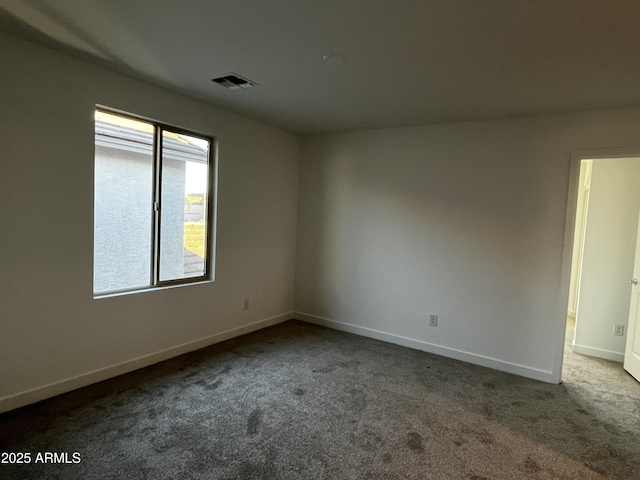 carpeted empty room featuring visible vents and baseboards