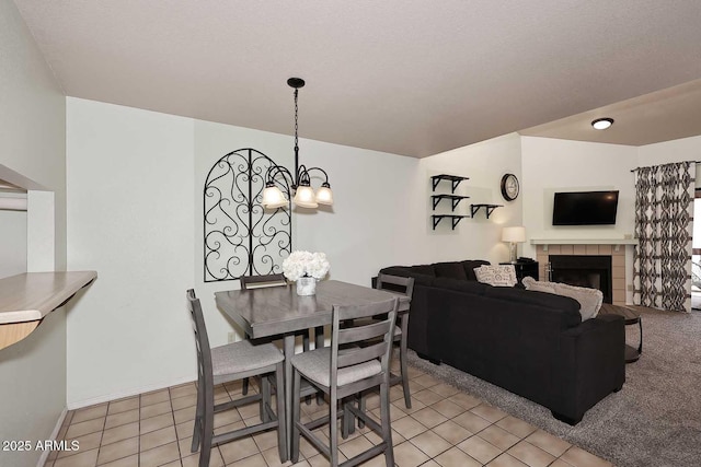 205 N 74th St Unit 248, Mesa, AZ 85207 - dining room with a chandelier, light tile patterned floors, a tile fireplace, and baseboards