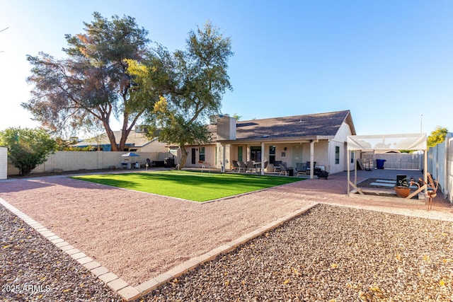 rear view of property with a patio area and a yard