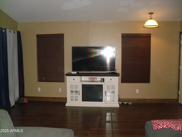 living area with baseboards and wood finished floors