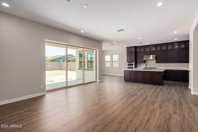 kitchen with a wealth of natural light, sink, an island with sink, and wood-type flooring