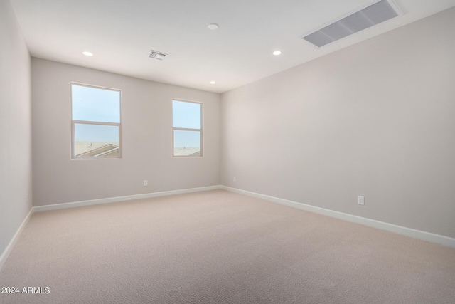 unfurnished room featuring light carpet