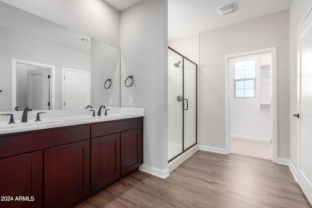 bathroom featuring hardwood / wood-style flooring, vanity, and an enclosed shower