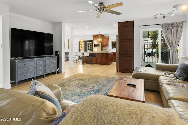 living room with ceiling fan and light hardwood / wood-style floors