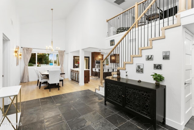 entrance foyer featuring dark wood-type flooring, a chandelier, and a high ceiling