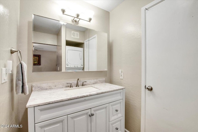 bathroom with stacked washer / dryer and vanity