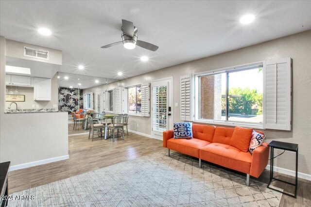 living room featuring light hardwood / wood-style floors and ceiling fan