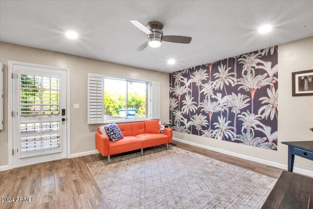 living area featuring wood-type flooring and ceiling fan