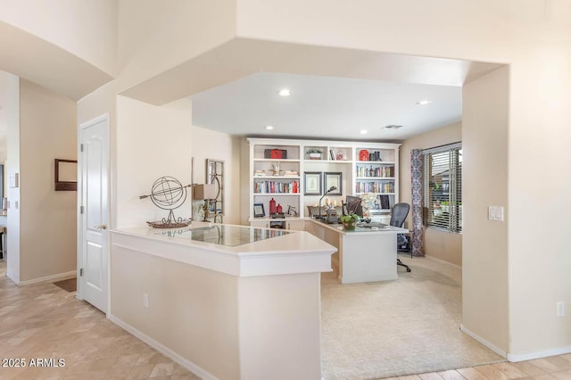 kitchen with a peninsula, baseboards, built in features, and recessed lighting