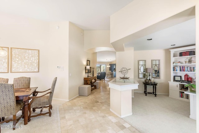 dining room with baseboards and arched walkways