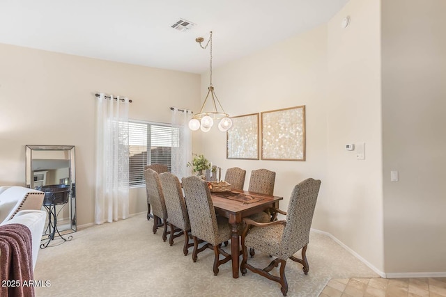 dining room with a notable chandelier, light colored carpet, visible vents, and baseboards