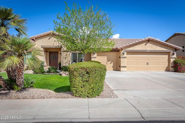 view of front of house featuring an attached garage, driveway, a tiled roof, and stucco siding