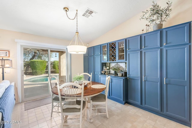 dining room with lofted ceiling and visible vents