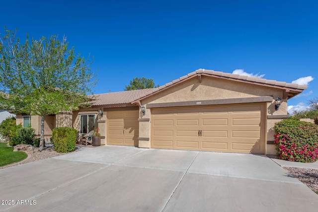 ranch-style home with a garage, concrete driveway, a tile roof, and stucco siding