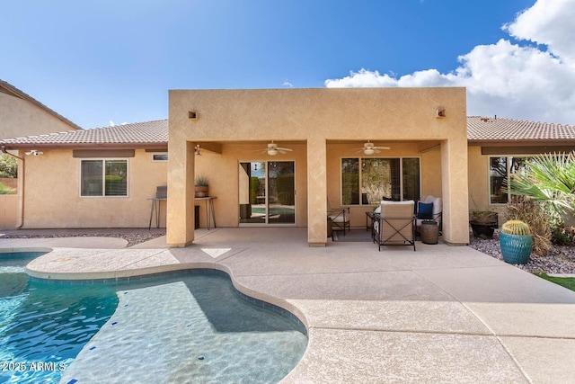 back of house featuring ceiling fan, a patio, a tiled roof, an outdoor pool, and stucco siding