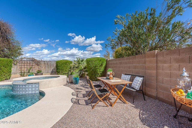 view of patio with a fenced backyard, outdoor dining area, a fenced in pool, and an in ground hot tub