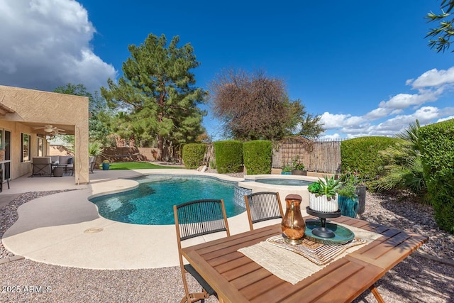 view of swimming pool featuring a fenced backyard, a pool with connected hot tub, ceiling fan, and a patio