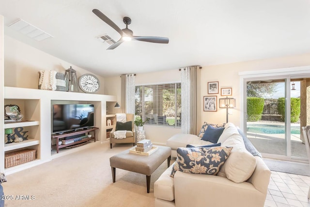 living area featuring built in features, visible vents, a ceiling fan, carpet flooring, and vaulted ceiling