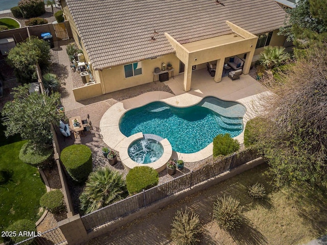 view of pool featuring a pool with connected hot tub, a patio area, and a fenced backyard