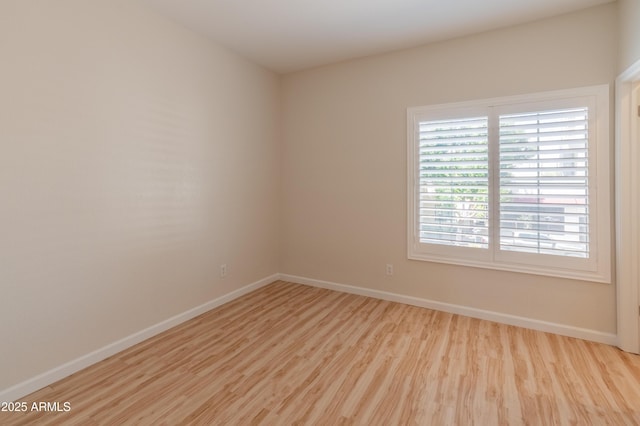 unfurnished room with baseboards and wood finished floors