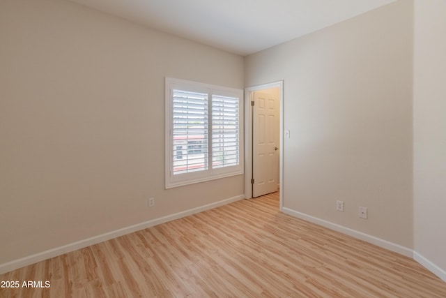 unfurnished room featuring baseboards and wood finished floors