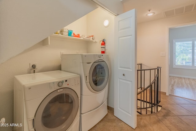 washroom featuring visible vents, laundry area, independent washer and dryer, and light tile patterned floors