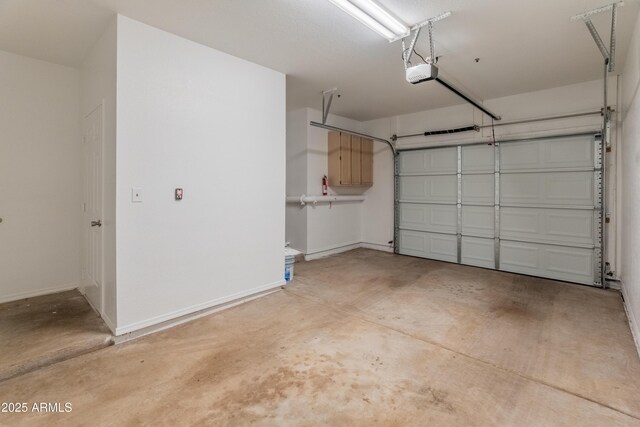 garage with baseboards and a garage door opener
