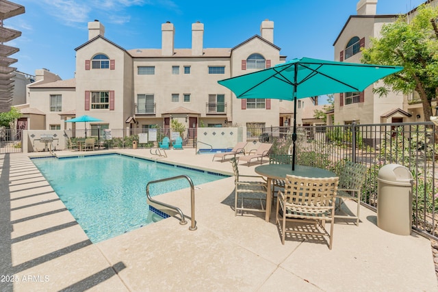 community pool featuring fence and a patio area