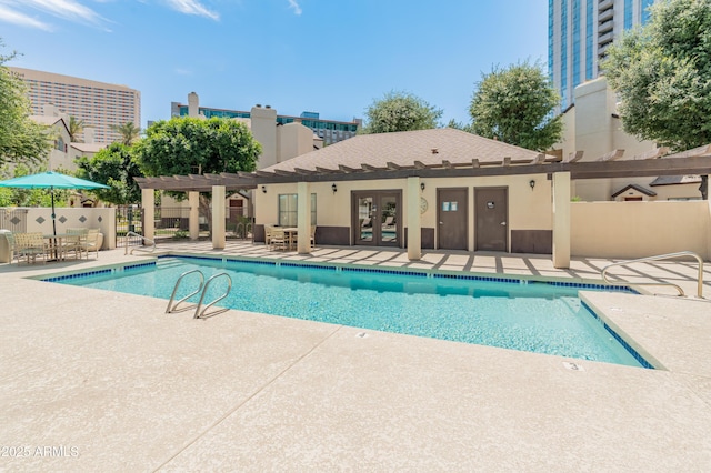 community pool with a pergola, a patio area, fence, and french doors