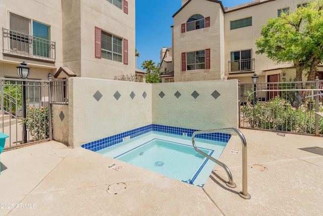 view of swimming pool featuring fence and a community hot tub